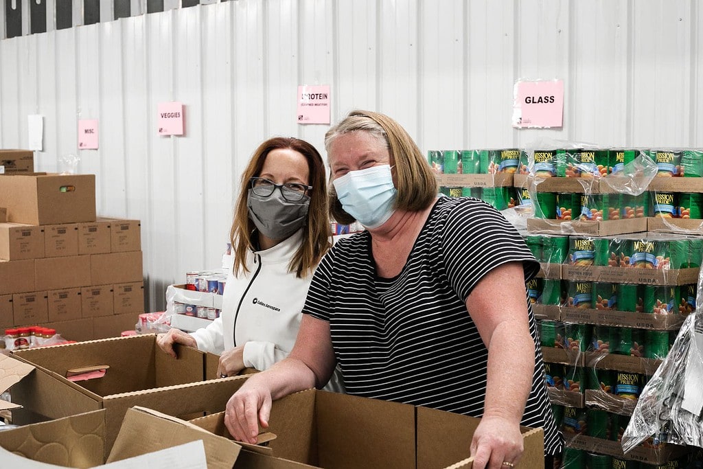 Photo of two masked volunteers smiling.