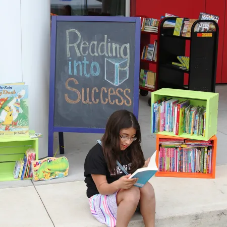 Child reading a book to promote reading success.